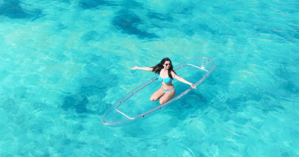 Drone shot: woman posing on a clear kayak in Aruba