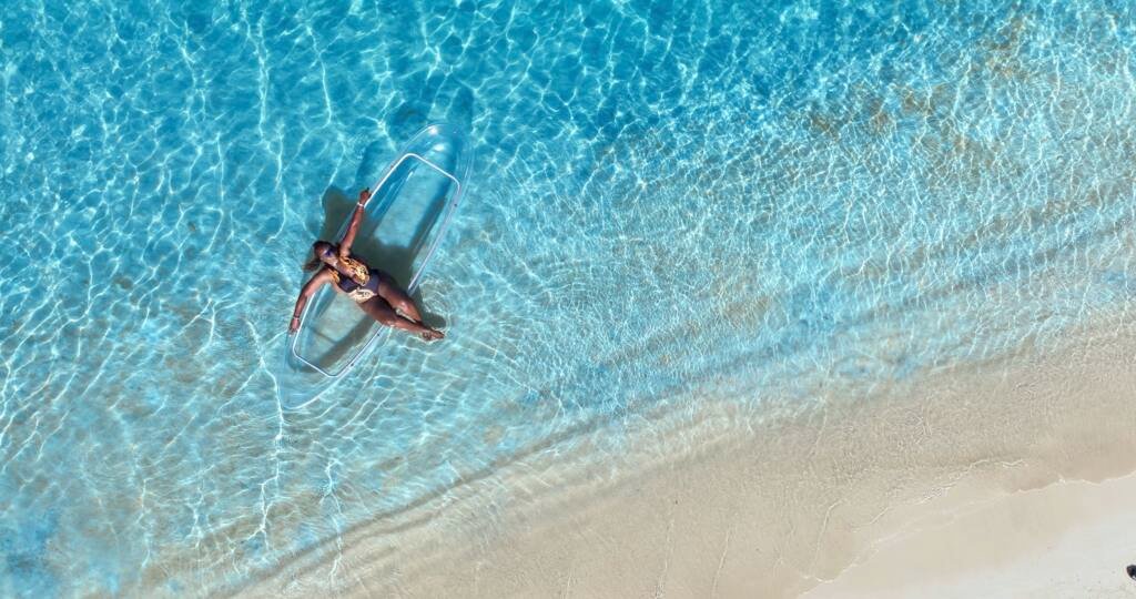 Drone shot: clear kayak along the shoreline, seen from above in Aruba