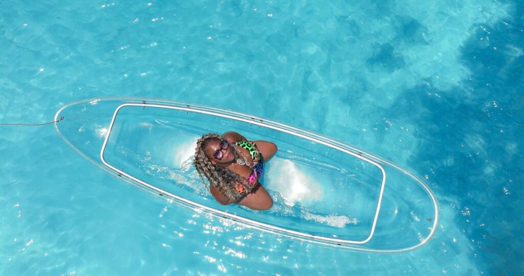 Drone shot: woman posing inside a clear kayak in Aruba