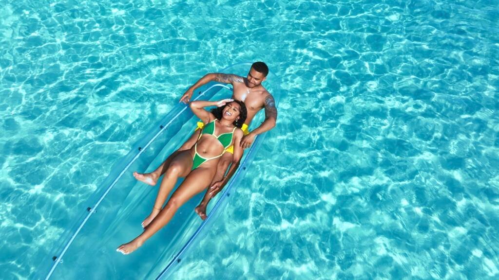 Drone shot: couple posing in a clear kayak, overhead view in Aruba
